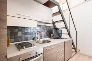 a small kitchen with a sink and a ladder at Parioli Modern Studio in Rome
