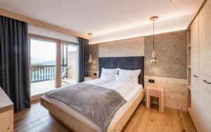 a bedroom with a large bed and a large window at La Majun Fornellahof in Antermoia +56 photos