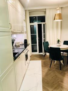 a kitchen and dining room with a table and chairs at GOLD APARTMENT Piotrkowska 37 in Łódź