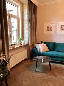 a living room with a green couch and a window at GOLD APARTMENT Piotrkowska 37 in Łódź