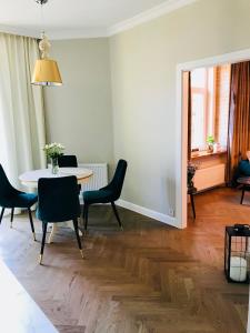 uma sala de jantar com mesa e cadeiras em GOLD APARTMENT Piotrkowska 37 em Lódź