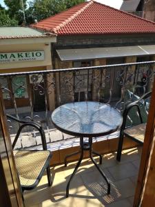 a table and chairs on a balcony at Georgios Rooms in Kalabaka