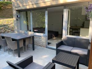 a patio with a table and chairs and a couch at Les Terrasses de Malmedy 22 Studio 341 in Malmedy
