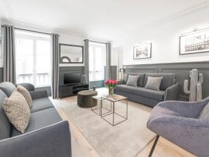 a living room with two couches and a tv at LivinParis - Luxury 3 Bedrooms Le Louvre II in Paris