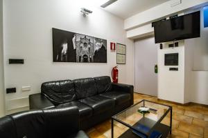 salon z czarną skórzaną kanapą i telewizorem w obiekcie In Riva Al Lago w Como