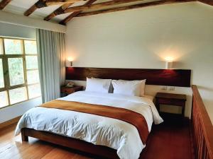 a bedroom with a large bed and two windows at Hotel La Casona De Yucay Valle Sagrado in Urubamba