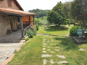 a yard next to a building with a house at Casa Rural El Pilar in Acebo