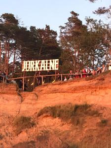 Un groupe de personnes debout au sommet d'une colline en terre dans l'établissement Avoti, à Jūrkalne