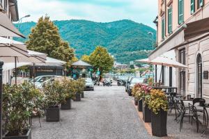 eine Straße in einer Stadt mit Tischen, Stühlen und Pflanzen in der Unterkunft In Riva Al Lago in Como