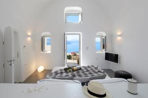 a white room with two beds and a table at Elegant Santorini House 3 Bedroom Villa Caldera View-Outdoor Hot Tub Oia in Thólos +58 photos