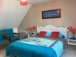 um quarto com uma cama com almofadas azuis e vermelhas em Gites Bellevue em Beauvoir