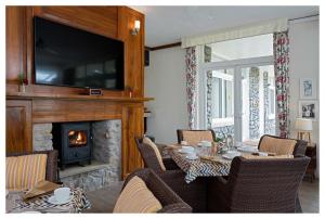 a living room with a table with chairs and a fireplace at Wordsworth Lodge in Mount Ābu