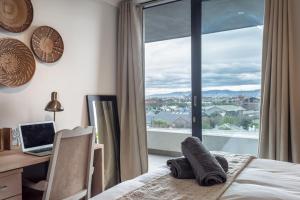 1 dormitorio con escritorio, ordenador portátil y ventana en Tranquil, Spacious, Quiet Trendy with a View, en Ciudad del Cabo
