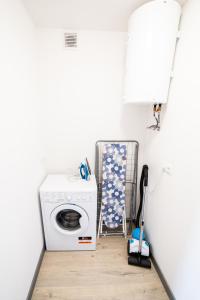 a laundry room with a washing machine and a chair at Apartament Piano Centrum in Racibórz