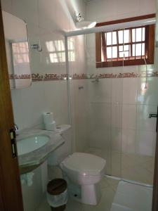 y baño con aseo, lavabo y ducha. en Chale da Ana, en Santo Antônio do Pinhal
