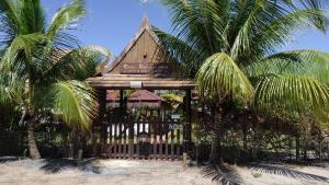 un edificio en la playa con dos palmeras en Pousada Thai Bungalows-Taipu de Fora, en Barra Grande