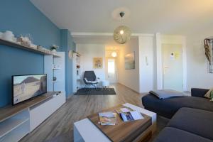 ein Wohnzimmer mit einem Sofa und einem TV in der Unterkunft Fürstenhof Apartment Wismar in Wismar
