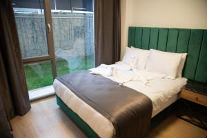 Bett mit grünem Kopfteil in einem Zimmer mit Fenster in der Unterkunft INN HOUSE LOFT SPA in Çankaya