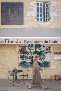 una persona caminando frente a un restaurante du golf en Le Florida Auberge contemporaine, en Castéra-Verduzan