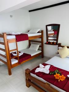 a room with two bunk beds and a mirror at Hotel Paso Realce in Guaduas