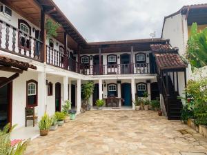 a courtyard of a house with a balcony at Pousada Marques in Paraty