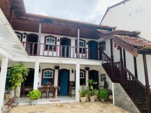 an old house with a balcony and a table at Pousada Marques in Paraty