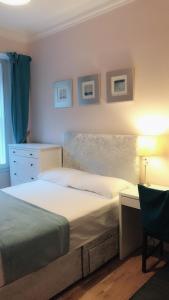 a bedroom with a bed and a desk with a lamp at Edinburgh City Holiday Apartments in Edinburgh