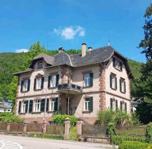 an old brick house with a balcony at Forsthaus Merzalben Hostel in Merzalben