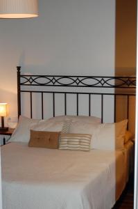 Cama con sábanas y almohadas blancas en Apartamento Garona, en Vielha