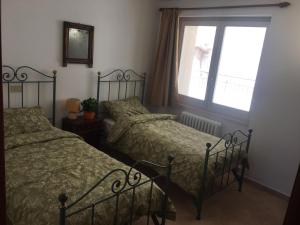 1 dormitorio con 2 camas y ventana en Residenza La Luce di Assisi, en Asís