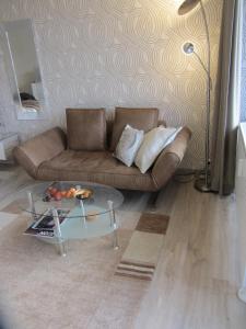 a living room with a couch and a glass table at Appartement Ausblick in Hahnenklee-Bockswiese