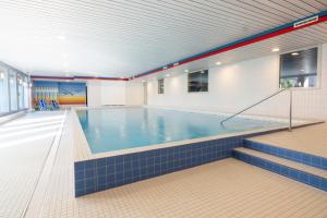 a large indoor swimming pool with blue tiles at Alpablüamli in Pany