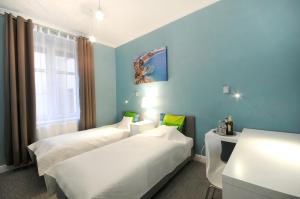 two beds in a room with blue walls at Jazzgot Apartamenty in Zielona Góra