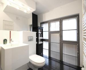 biała łazienka z toaletą i umywalką w obiekcie Jazzgot Apartamenty w Zielonej Górze