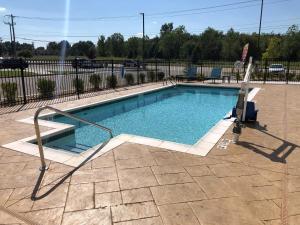 a swimming pool with a metal hand rail next to it at avid hotel Tulsa South - Medical District in Tulsa