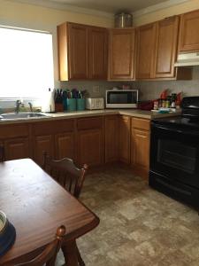 a kitchen with wooden cabinets and a table and a sink at Reel Simple Bolton Lake Cottage in Bolton +6 photos