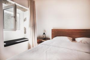 Santa BárbaraCasas da Ribeira的一间卧室，有一张白色的床和一扇窗户