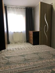 Schlafzimmer mit einem Bett, einem Fenster und einer Tür in der Unterkunft DMI Apartment in Iaşi