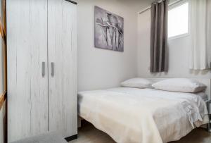 a bedroom with a white cabinet and a bed at Apartment Tomas in Split