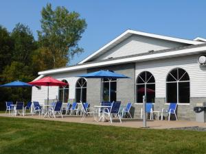 a group of chairs and umbrellas in front of a building at Northwoods Best Inn - Chetek in Chetek