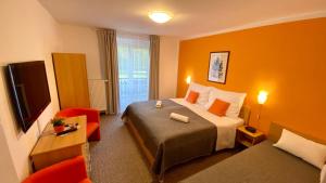 タトランスカ・ロムニツァにあるApartment Gudiのベッドとテレビが備わるホテルルームです。