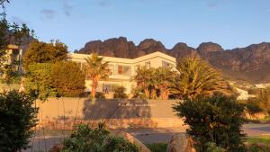 a large house with mountains in the background at Finchley Guesthouse in Cape Town