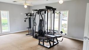 a gym with several tread machines in a room with windows at Comfy 1BR Apartment - Ideal for Traveling Nurses & Professionals in Gainesville