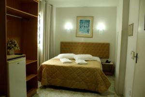 1 dormitorio con 1 cama con 2 toallas en Hotel Pousada Valintur, en Balneário Camboriú