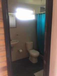 uma casa de banho com um WC, um lavatório e uma cortina de chuveiro azul. em Finca San Carlos 100% pet friendly em Zipaquirá