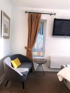 a living room with a chair and a television at Clanrye House Guest Accommodation in Newry