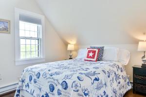 a bedroom with a blue and white bed and a window at 9 Green Hollow Road in Nantucket
