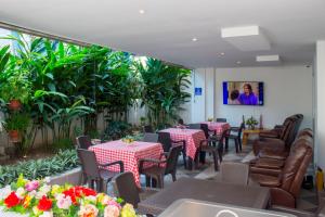 um restaurante com mesas, cadeiras e plantas em Hotel Boutique M em Barranquilla