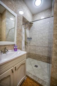 a bathroom with a shower and a sink and a mirror at Apartment on Kommunisticheskaya in Smolensk