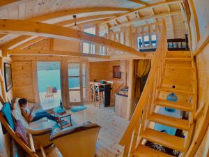 a person sitting on a couch in a tiny house at Lake House Perucac in Rastište